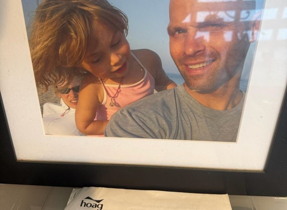 A framed close-up photo of Eric smiling beside a young girl