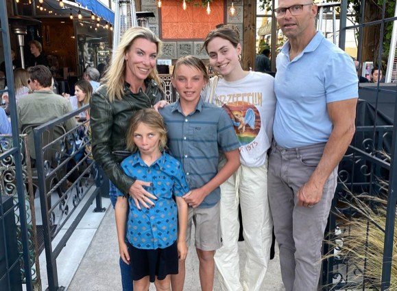 Eric in a light blue polo standing with family outside a restaurant